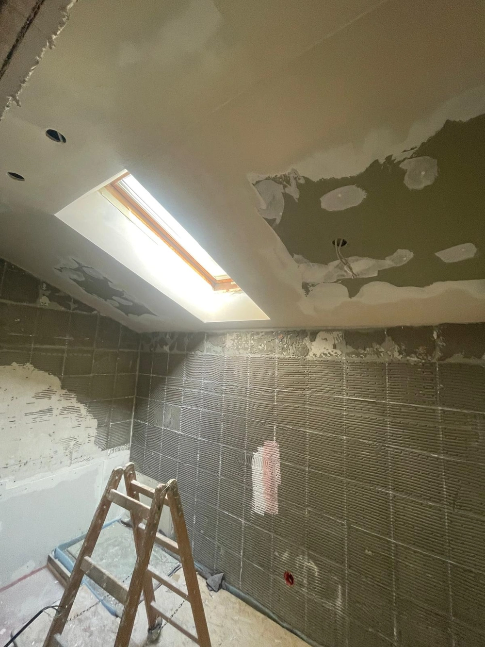 Trockenbauarbeiten mit Rigipsplatten und Spachtelarbeiten an Badezimmerdecke mit Dachfenster